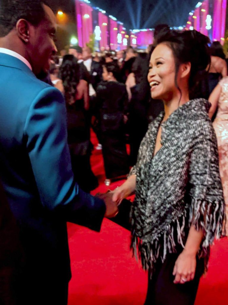 Anna Burns greeting a guest on the red carpet at a media event